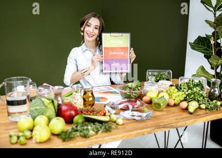 La promotion d'une saine alimentation équilibrée diététique assis à la table pleine de produits variuos Banque D'Images