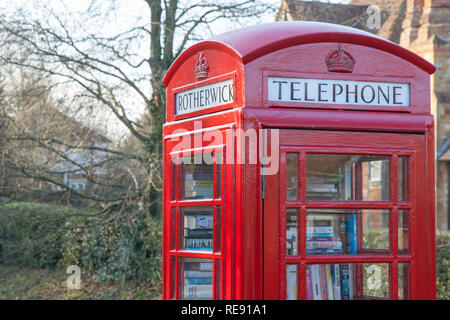 Boîte de téléphone rouge anglais traditionnel dans un village de campagne, Rotherwick Hampshire. Banque D'Images