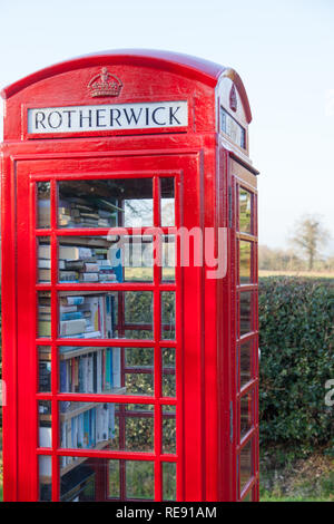 Boîte de téléphone rouge anglais traditionnel dans un village de campagne, Rotherwick Hampshire. Banque D'Images