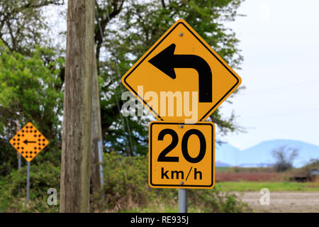 20 km/h panneau jaune avec flèche d'avertissement bend Banque D'Images