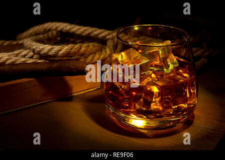Whisky, cognac ou brandy avec de la glace dans les verres et les fumeurs de pipe en bois rustique, d'arrière-plan de l'espace de copie. Banque D'Images