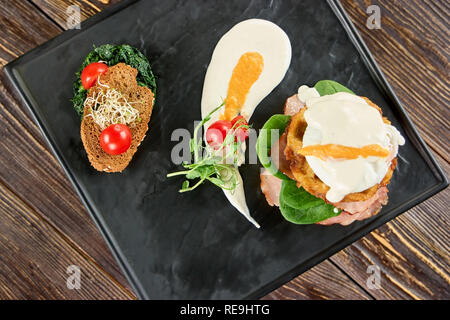 Des œufs, du pain et des légumes dans des repas différents. Étrange à la nourriture sur la plaque rectangle. Banque D'Images