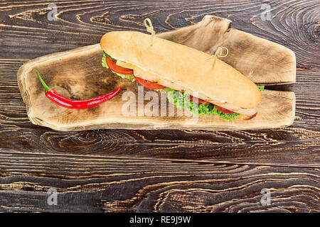 Sandwich Long et de piment fort, vue d'en haut. Chili Pepper et sandwich sur planche de bois, vers le bas. Banque D'Images