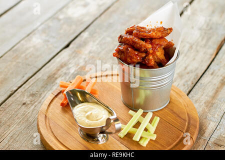 Des ailes de poulet grillé à la sauce tomate. Servi dans un godet en aluminium. Banque D'Images