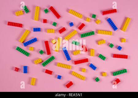 Les briques en plastique bâtiment coloré sur fond rose. L'élaboration d'arrière-plan toys Banque D'Images