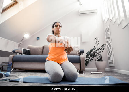 African American Woman avec les cheveux attachés faisant exercice spécial pour palms Banque D'Images