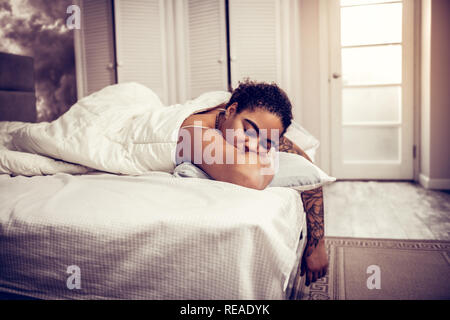 Femme brune avec des sourcils épais en blanc mauvais sommeil Banque D'Images