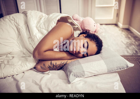 Bon à la dame brune dormir calmement couverts avec douce couverture Banque D'Images