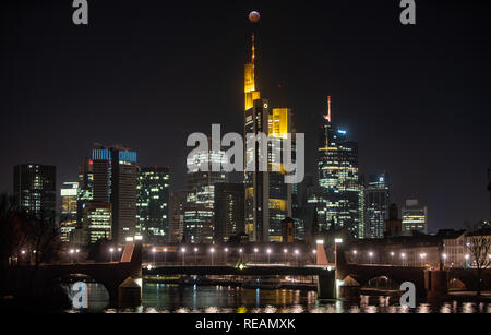 21 janvier 2019, Hessen, Frankfurt/Main : Comme un rouge, soi-disant 'blood moon', la pleine lune est au-dessus de la Frankfurt gratte-ciel et la Commerbank (M), alors qu'il siège comme suit dans l'ombre de la terre. L'ombre de la core couvre la surface visible de la lune. La lune, le soleil et la terre sont en ligne. Photo : Frank Rumpenhorst/dpa dpa : Crédit photo alliance/Alamy Live News Banque D'Images