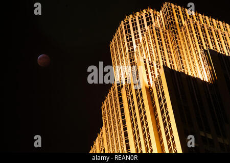 20 janvier 2019 - Minneapolis, Minnesota, USA - Centre-ville de Minneapolis Wells Fargo Center avec la pleine lune en passant par l'éclipse lunaire totale. Banque D'Images