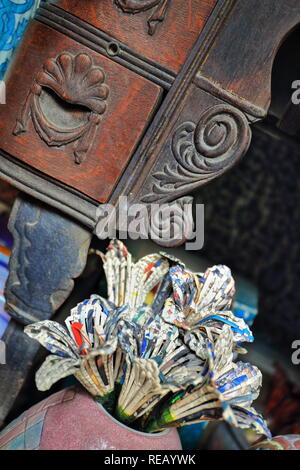 Bouquet de fleurs artificielles fabriqués à partir de journaux-magazines en lanières et liés ensemble dans un vase en céramique placés sur le plancher à la fo Banque D'Images