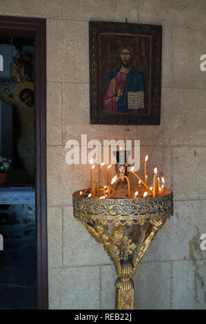 L'île de Rhodes, Grèce. 05/28/2018. Un stand d'or avec des bougies allumées dans les intentions. Le chemin menant à de gigantesques croix près de monastère de Filerimos. Banque D'Images