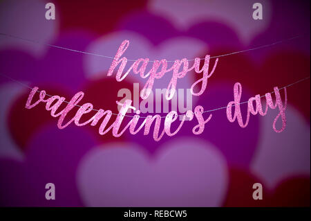 Happy Valentine's Day Message script scintillants en accrochant dans une bannière avec abstract love heart overlay Banque D'Images