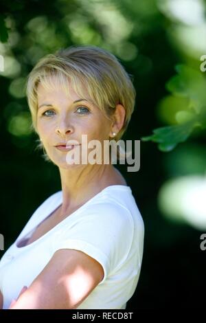 Portrait d'une femme, au début de la quarantaine, dans le jardin, regardant la caméra, smiling Banque D'Images