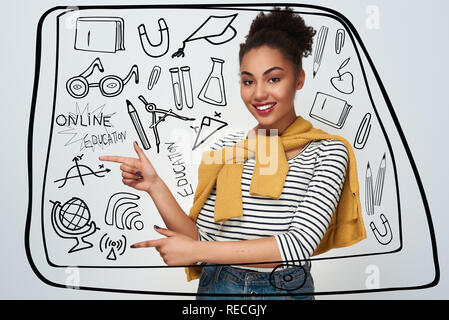 Jeune femme studio isolés dans mur blanc pointant de côté à deux mains sur l'espace libre à la caméra smiling happy Banque D'Images