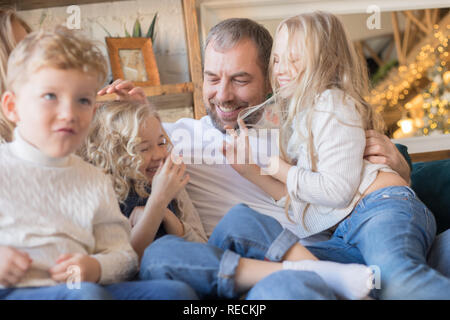 Happy Family est assise sur le canapé et s'amusant. Banque D'Images