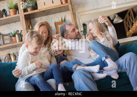 Happy Family est assise sur le canapé et s'amusant. Banque D'Images