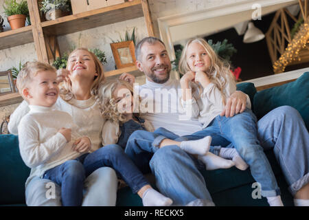 Happy Family est assise sur le canapé et s'amusant. Banque D'Images