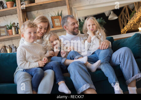 Happy Family est assise sur le canapé et s'amusant. Banque D'Images