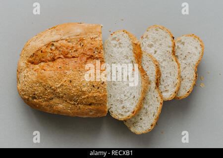Tranches de pain avec miche de pain sur fond gris vue supérieure Banque D'Images