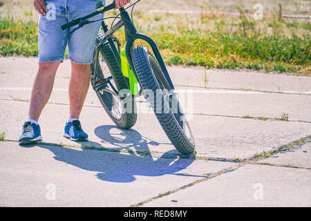 Guy va avec le vélo sur la route Banque D'Images