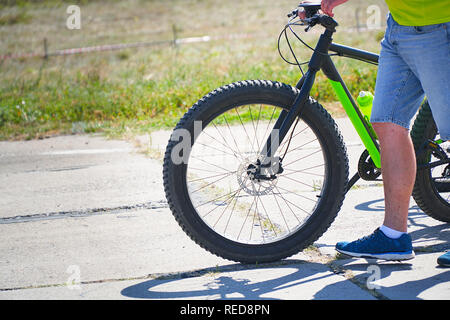 Guy va avec le vélo sur la route Banque D'Images