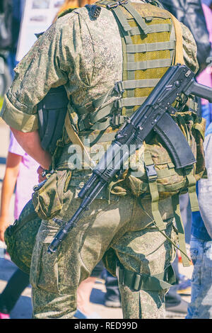 Soldat de camouflage avec un fusil derrière son dos Banque D'Images
