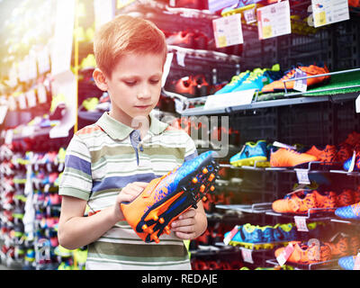 Garçon avec des chaussures dans le magasin de sport Banque D'Images