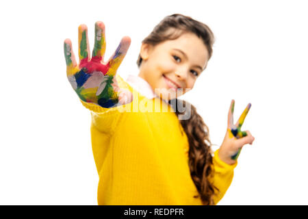 Portrait of smiling schoolgirl montrant la main peinte dans les peintures colorées et looking at camera isolated on white Banque D'Images