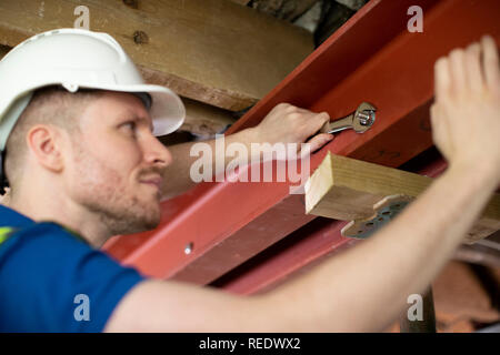 Travailleur de la construction en acier raccord en poutre de support plafond Maison rénovée Banque D'Images