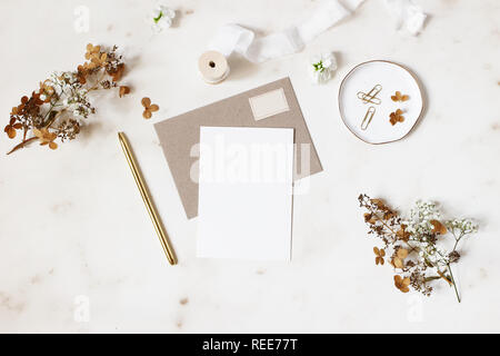 Anniversaire, mariage d'hiver féminin papeterie maquettes scène. Carte de voeux vierge, enveloppe kraft, golden pen, sec et d'hortensias fleurs de gypsophile. Ma Banque D'Images