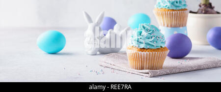 Easter cupcakes à la vanille, les oeufs colorés, cute bunny et jacinthe d'eau dans un pot de fleur. Maison de vacances bannière concept. Banque D'Images