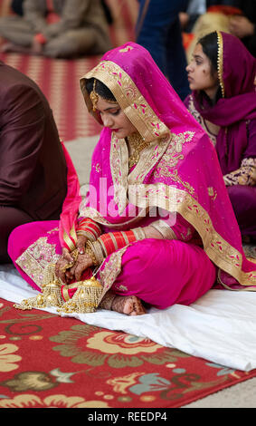 Un Sikh mariée assis au cours de sa cérémonie de mariage dans un temple sikh à Richmond Hill, Queens, New York. Banque D'Images