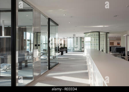 Open plan office avec vitrage de réflexion et l'espace de circulation. Siège de bureau Swiss Re, Zurich, Suisse. Architecte : Diener & Diener, 2017. Banque D'Images