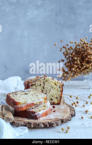 Tranches de gâteau sur un plateau en bois avec des fleurs séchées Banque D'Images