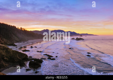 Vue de la plage Crescent, Cannon Beach, Haystack Rock et d'un océan à l'Hug Point de parc d'état d'Ecola au lever du soleil, de l'Oregon. Banque D'Images