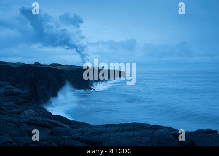 Panache de vapeur et de littoral de la lave entrant dans l'océan vu de la mer, Holei Arch donnent sur Hawaii Volcanoes National Park, Île d'Hawaï. Banque D'Images