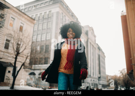 Heureux jeune femme noire est à pied de la rue et de sourire. Libre. Banque D'Images