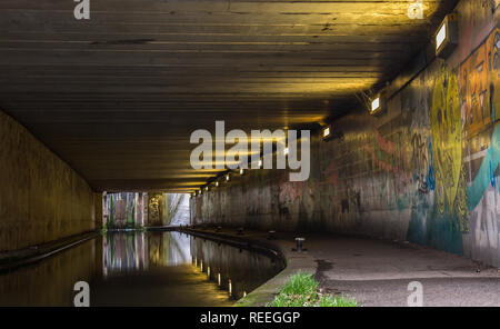 Paysage du côté du canal de l'écriture graffiti vaporisés sur les murs en passage inférieur pour piétons, Kidderminster UK. Fléau de nos cours d'eau ou du patrimoine d'expression artistique ? Banque D'Images