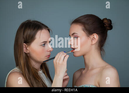 Femme artiste de maquillage Pinceaux de maquillage de portefeuille et appliquer le rouge à lèvres sur la lèvre du modèle de mode parfait Banque D'Images