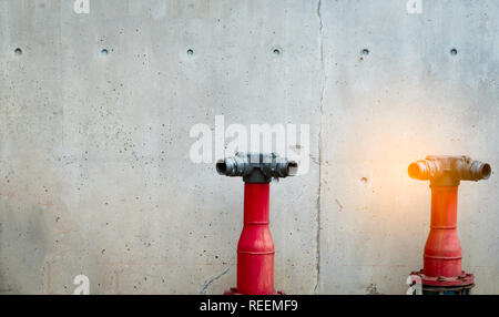 La pompe de la sécurité incendie sur plancher de béton du bâtiment en béton. Système de rideau de système de lutte contre l'incendie. La plomberie protection incendie. Feu rouge en face de la pompe Banque D'Images