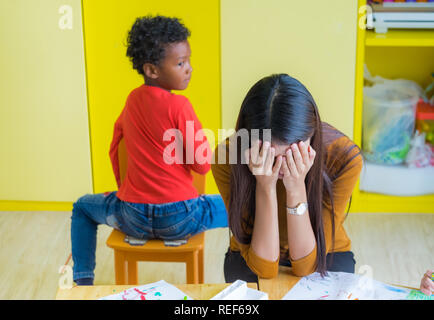 Obtenir de l'enseignant de tête avec deux enfants naughty en classe à l'école maternelle Banque D'Images