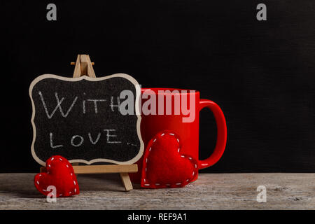 Avec amour à la main la phrase avec craie blanche sur tableau noir Banque D'Images