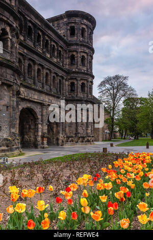 Porta Nigra au coucher du soleil, les tulipes avant-plan, Trier, Allemagne Banque D'Images