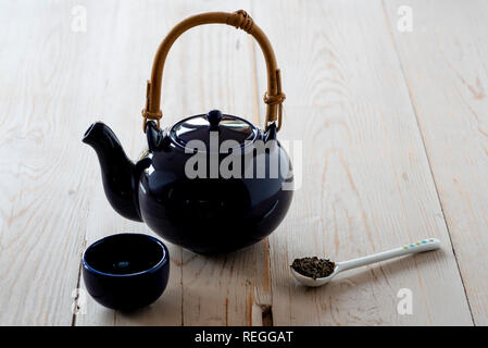 Vue de l'oriental, théière et tasse de thé vert avec des feuilles. Banque D'Images