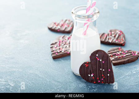 Coeurs de chocolat cookies pour la Saint-Valentin avec le glaçage et saupoudre avec du lait Banque D'Images