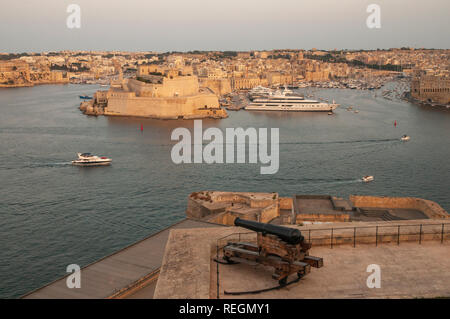 Un seul canon au Batterie Salut pointant vers le Grand Port et les villes de Senglea et Paola de Upper Barrakka Gardens, La Valette, Malte. Banque D'Images