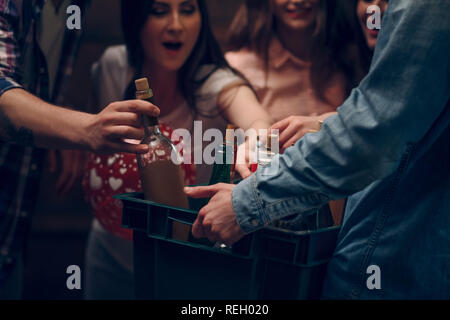 Man holding box avec des bouteilles de champagne lors d'une fête Banque D'Images