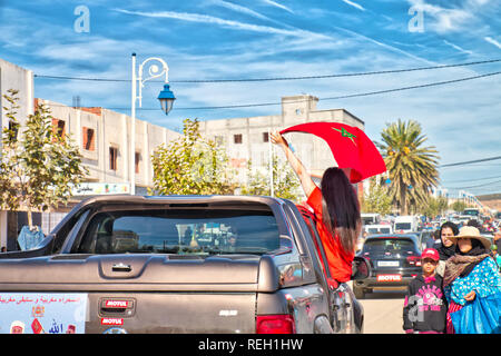 Oued Laou, Chefchaouen, Maroc - le 3 novembre 2018 : Une jeune femme brune aux cheveux longs, les vagues le drapeau marocain soulevées dans une voiture Banque D'Images