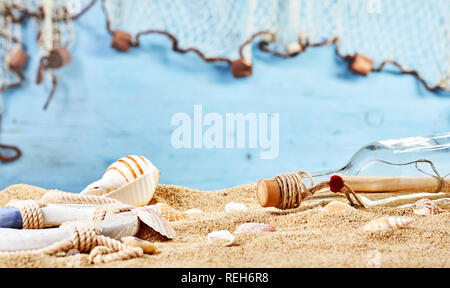 Plage Marine Nature morte avec mystère lettre dans une bouteille échouée sur le sable doré parsemé de coquillages et d'une vie sur l'anneau bleu avec copie espace Banque D'Images